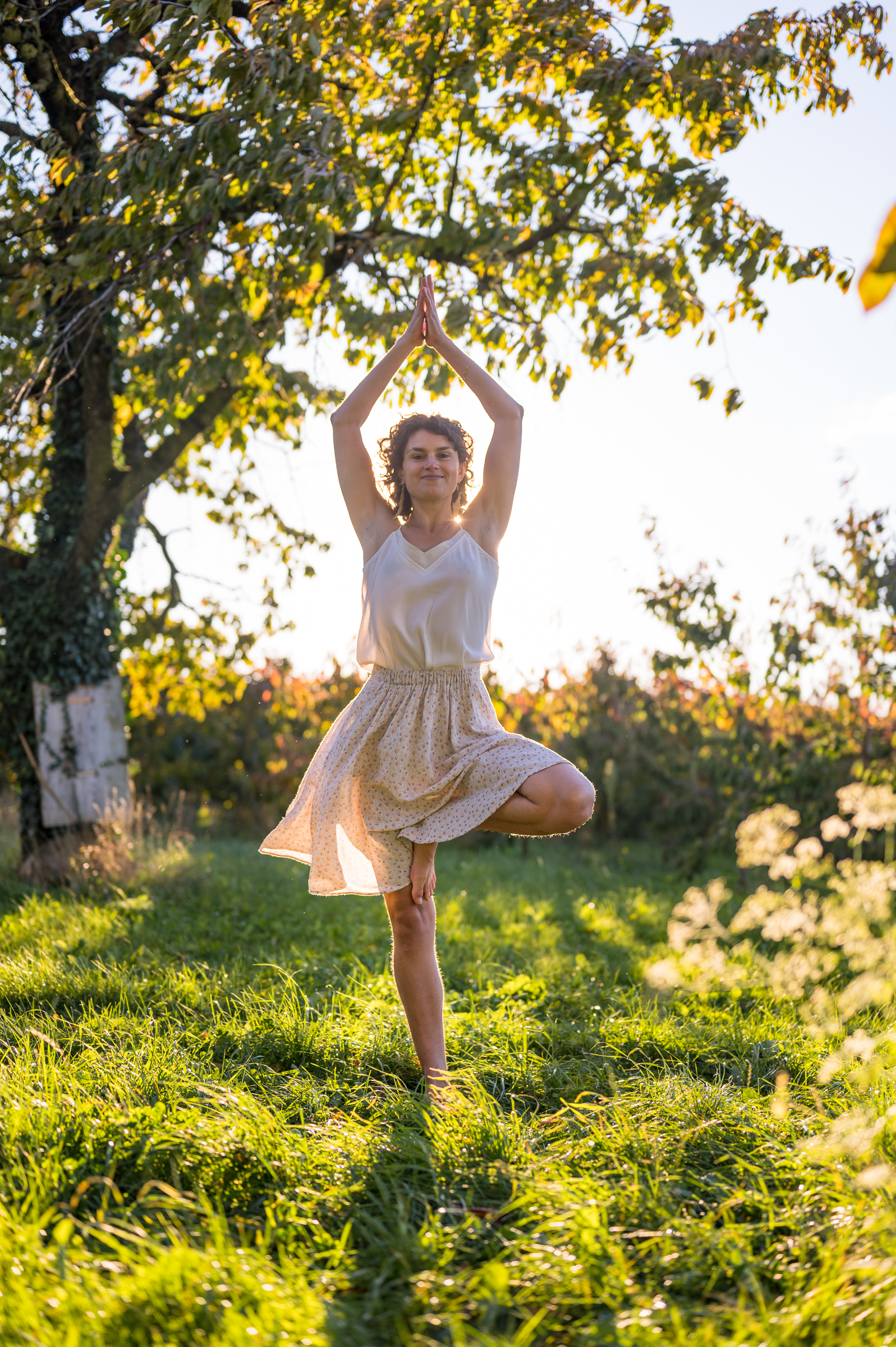 Marjorie qui fait la figure de yoga de l'arbre, en plaine nature